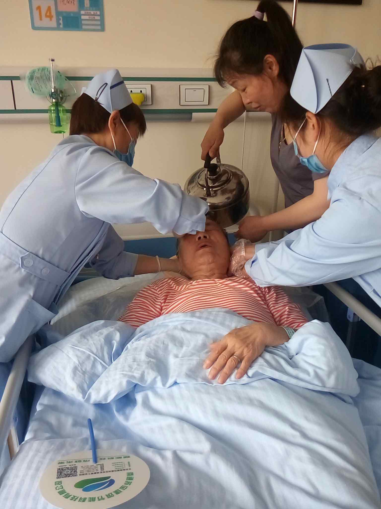 护理员和护士一起为老人床上洗头